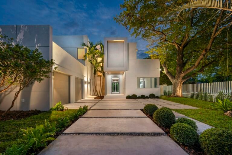 Casa branca moderna com caminho de acesso iluminado